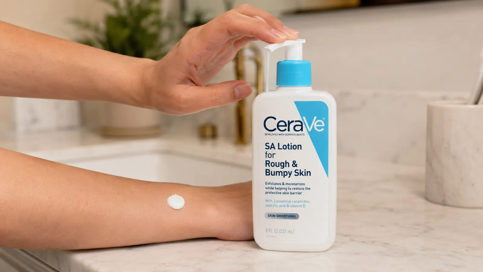 Hand pumping a small amount of white lotion from the CeraVe SA Lotion bottle onto the back of a forearm
