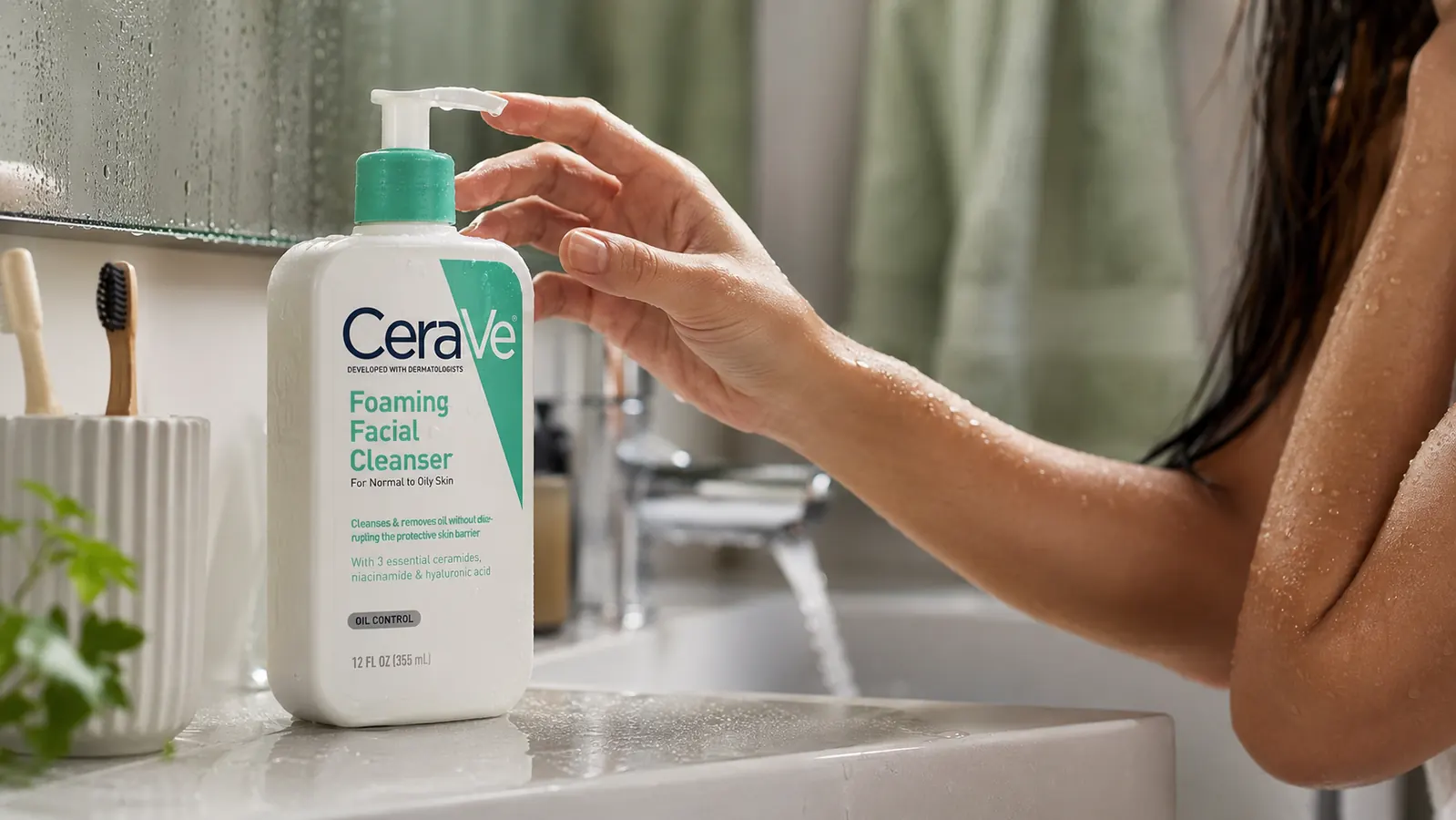 CeraVe Foaming Facial Cleanser bottle sitting on a bathroom sink next to a folded towel